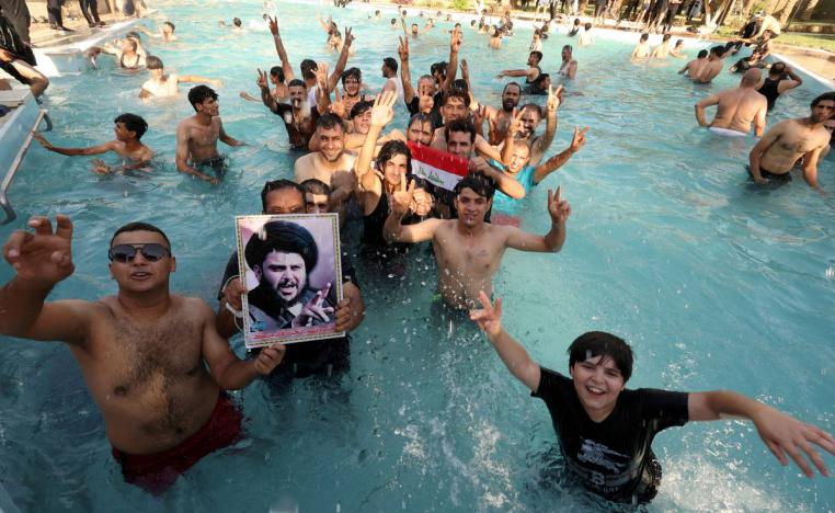 عراقيون في مسبح في بغداد يرفعون صورة لمقتدى الصدر