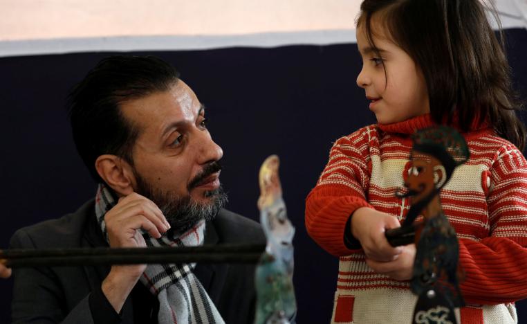 Shadi al-Hallaq, a puppeteer, is seen next to a disabled child during a performance in Damascus, Syria December 3, 2018.