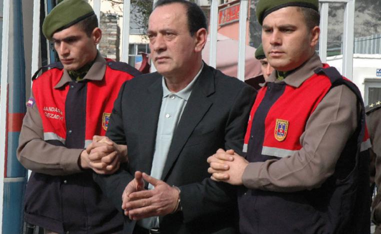 April 11, 2008 file photo, paramilitary police offices escort Alaattin Cakici before a trial in Istanbul.