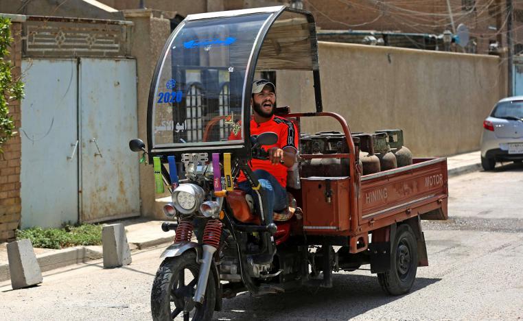 الشاب العراقي منتظر عباس يتنقل على عربة مثبتة الى دراجة نارية 