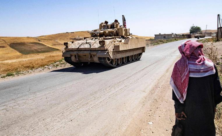 سوري في ريف الحسكة يراقب مرور مدرعة أميركية