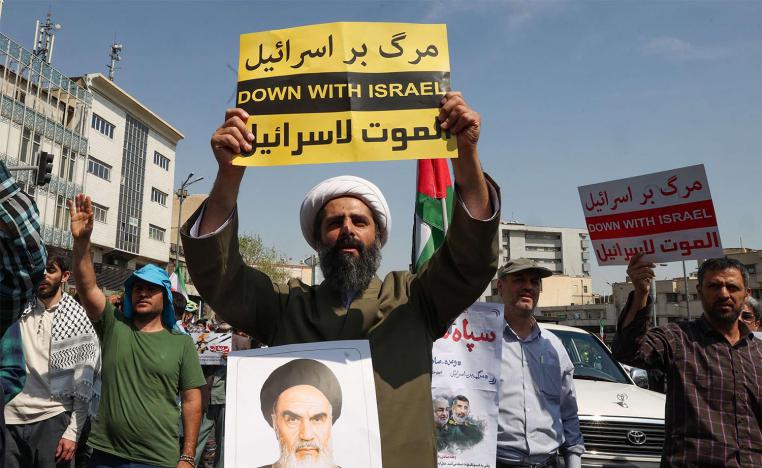 An Iranian Shiite Muslim cleric raises a placard during an anti-Israel demonstration after the Friday noon prayer in Tehran