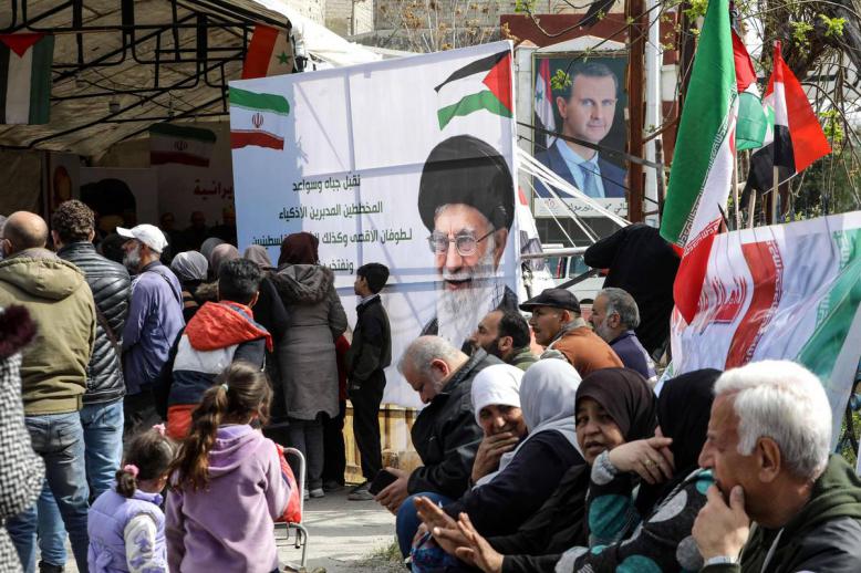فلسطينيون يرفعون صورا للأسد وخامنئي في مخيم اليرموك