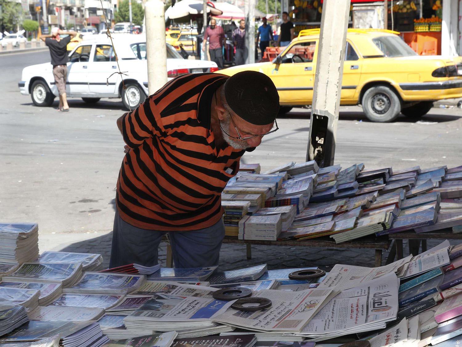 عراقي يستطلع عددا من الصحف اليومية