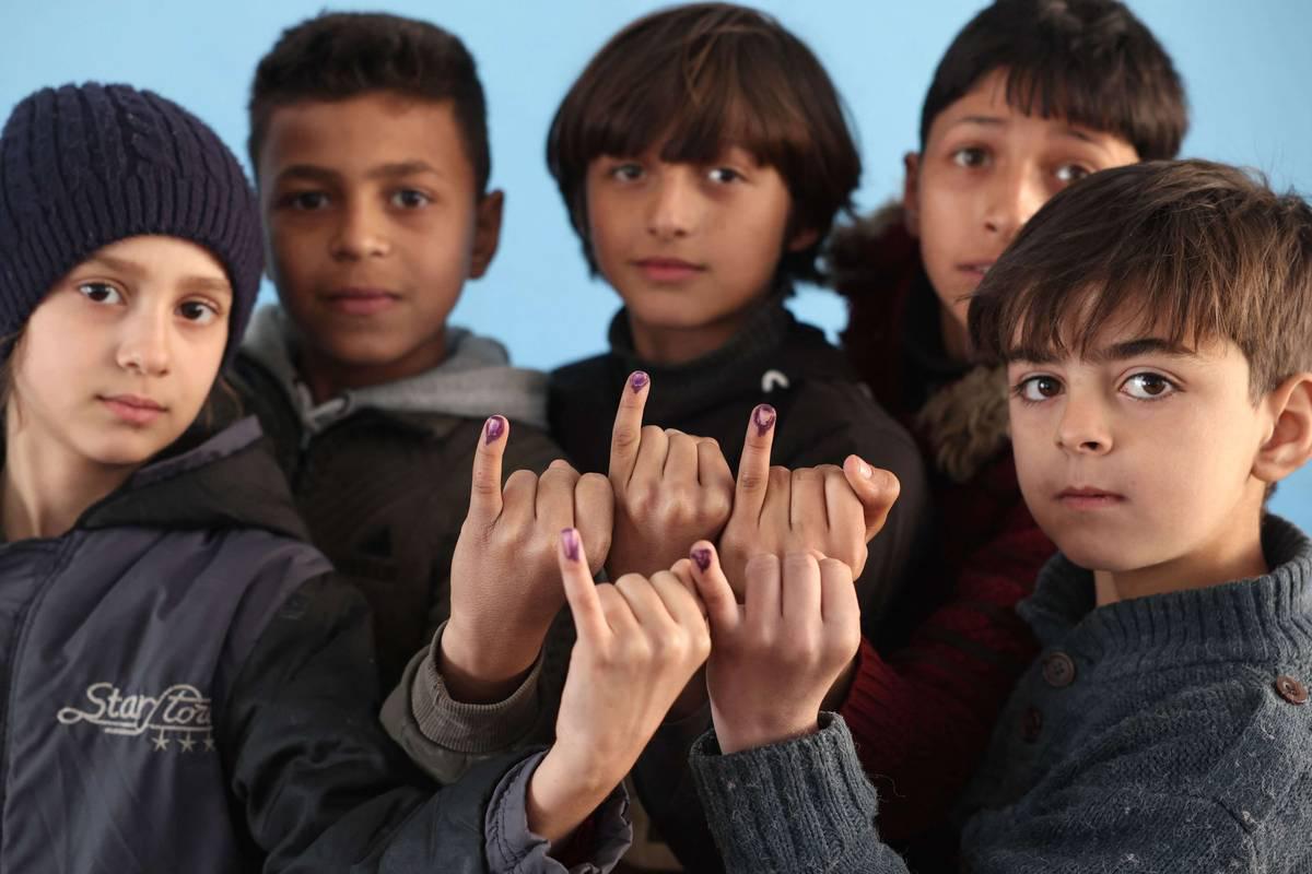 أطفال سوريون يعرضون اصابعهم بعد تلقي لقاحات في مخيم لجوء شمال سوريا
