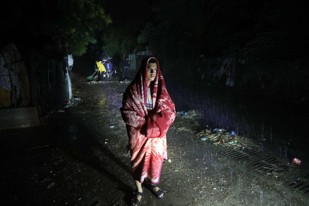 فلسطيني يتلحف بطانية اتقاء من أمطار دانيال في غزة