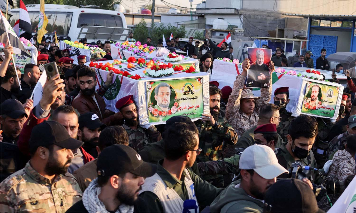 Mourners carry the coffins of Iraq's Kataib Hezbollah fighters who were killed by US airstrike