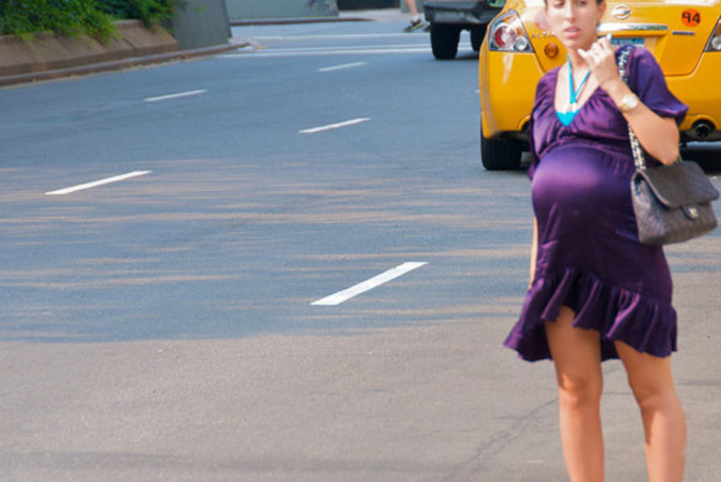 مرأة حامل على قارعة طريق يعج بالسيارات