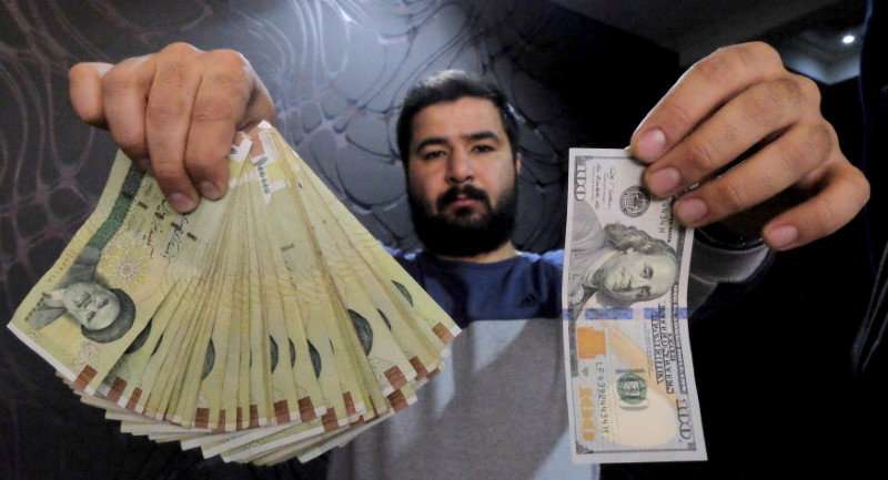 إيراني يعرض الفرق بين العملة الايرانية والعملة الأميركية