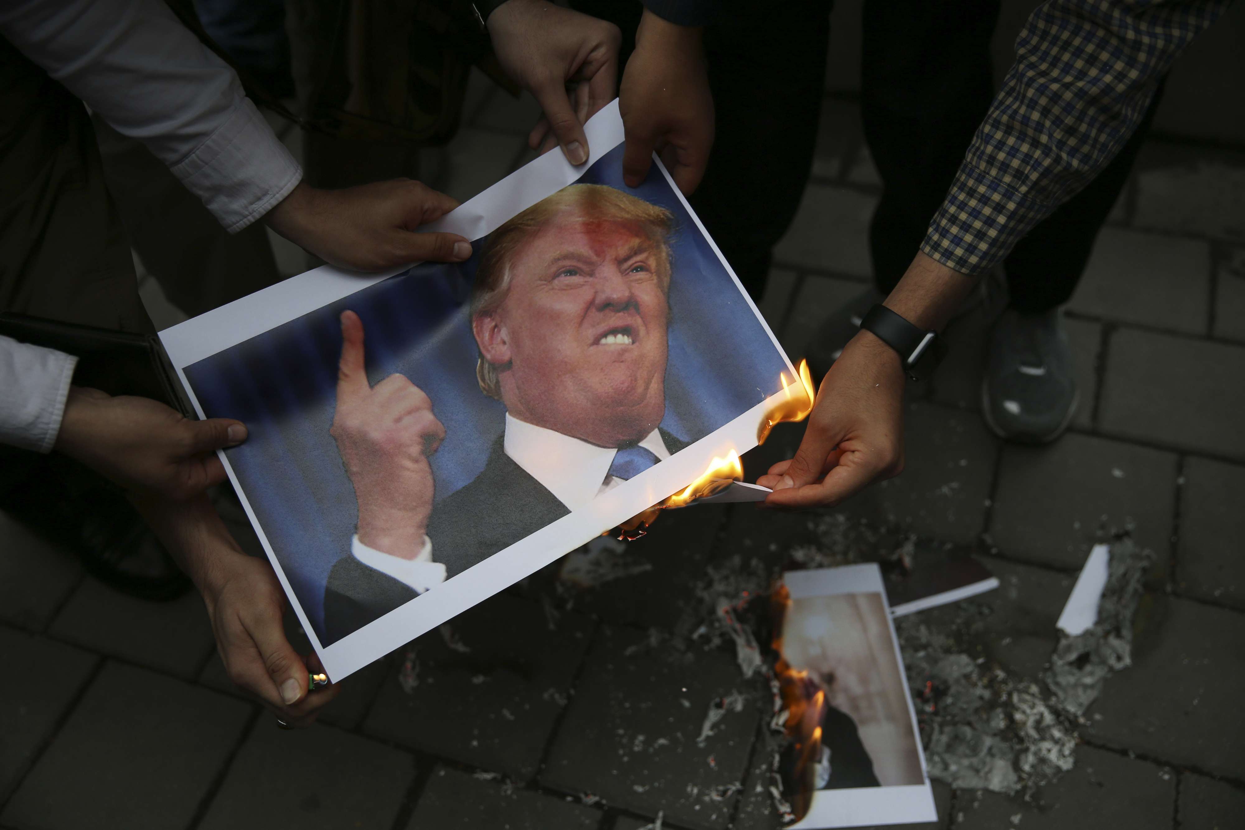 إيرانيون يحرقون صورة الرئيس الأميركي دونالد ترامب