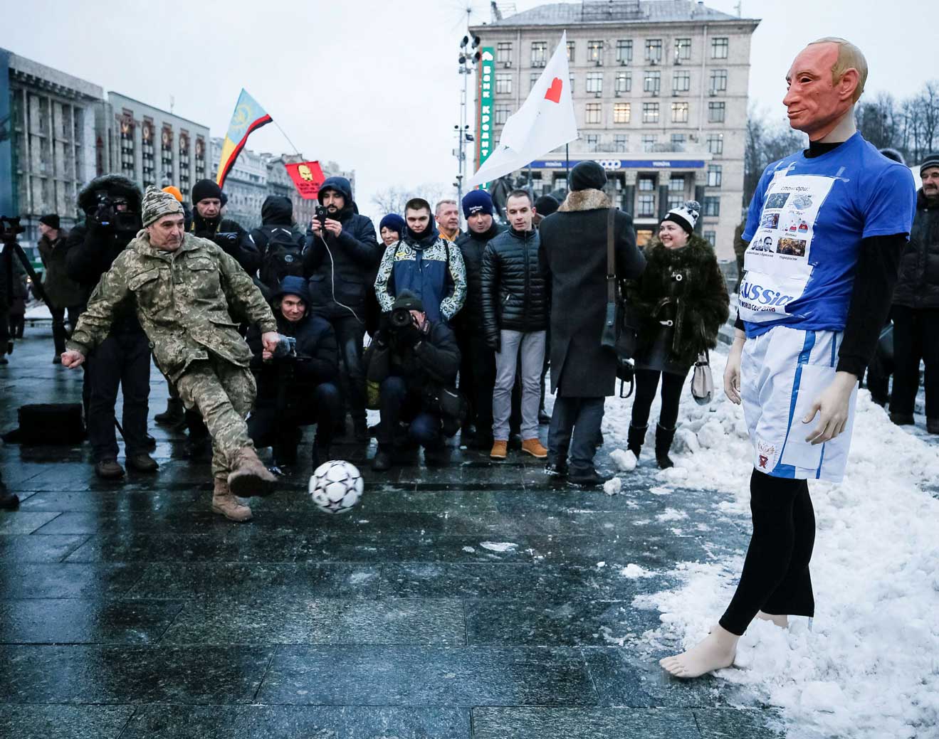 لاعب في المنتخب الاوكراني يسدد الكرة في اتجاه دمية تجسد فلاديمير بوتين اثناء مسيرة ضد استضافة روسيا لكأس العالم 