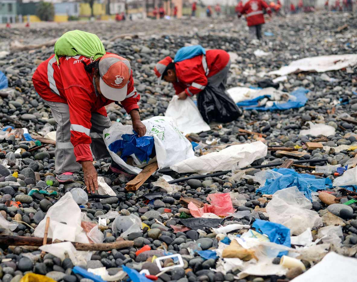 متطوعون يقومون بتنظيف نفايات بلاستيكية على شاطئ في ليما