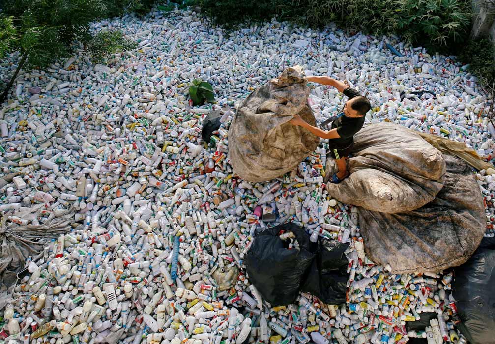 رجل فيتنامي يعمل على إعادة تدوير الزجاجات البلاستيكية 