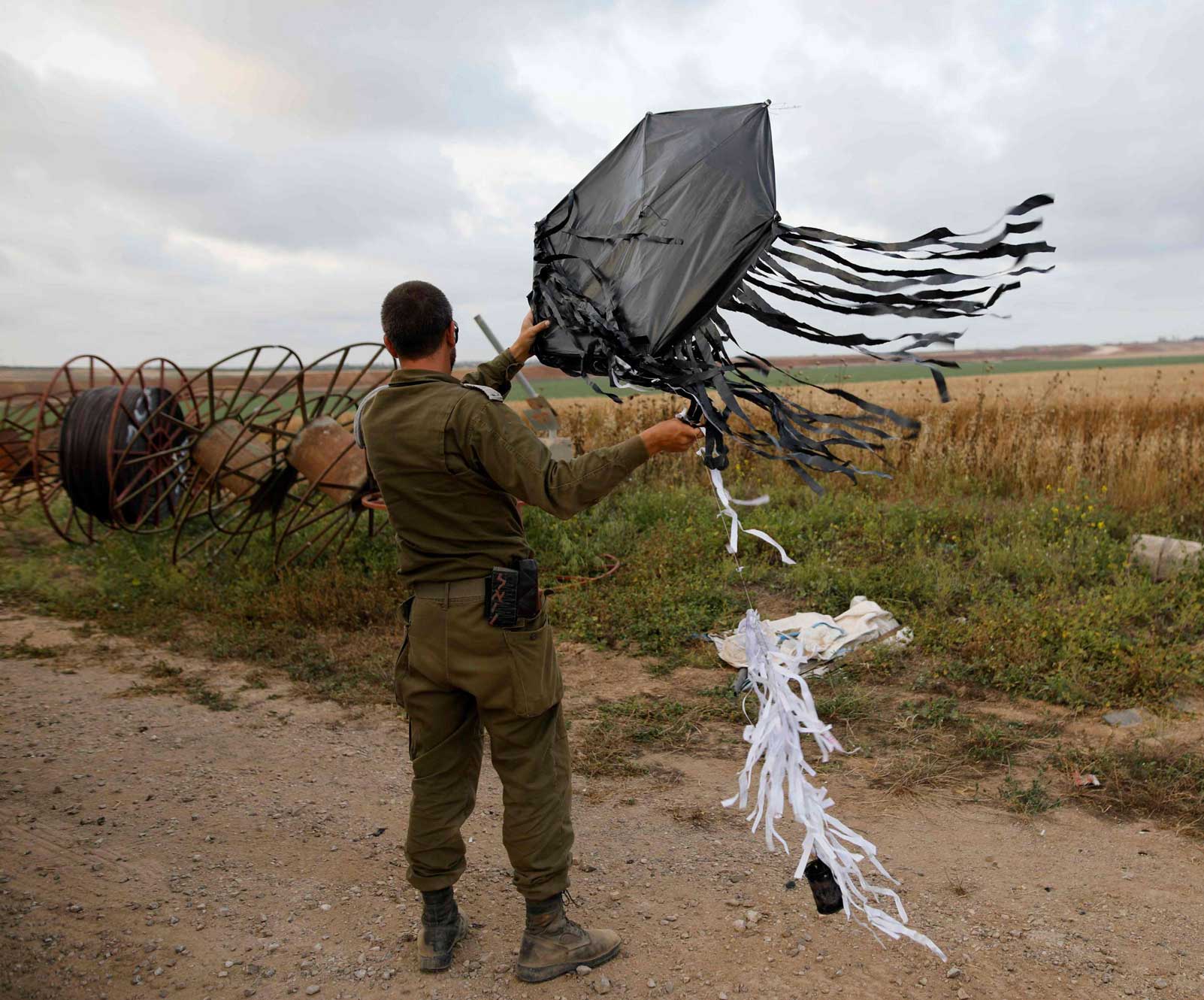 جندي اسرائيلي يمسك طائرة ورقية