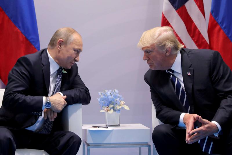 Russian President Vladimir Putin (L) talks to US President Donald Trump during their meeting at the G20 summit in Hamburg, last July