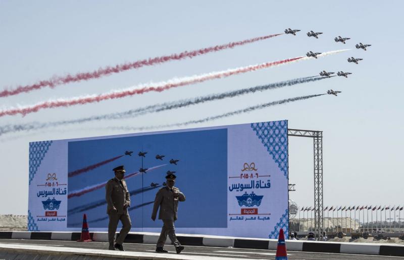 A file picture shows Egyptian Army officers walking in front of a huge screen during the opening ceremony of a waterway at the Suez Canal in Ismailia