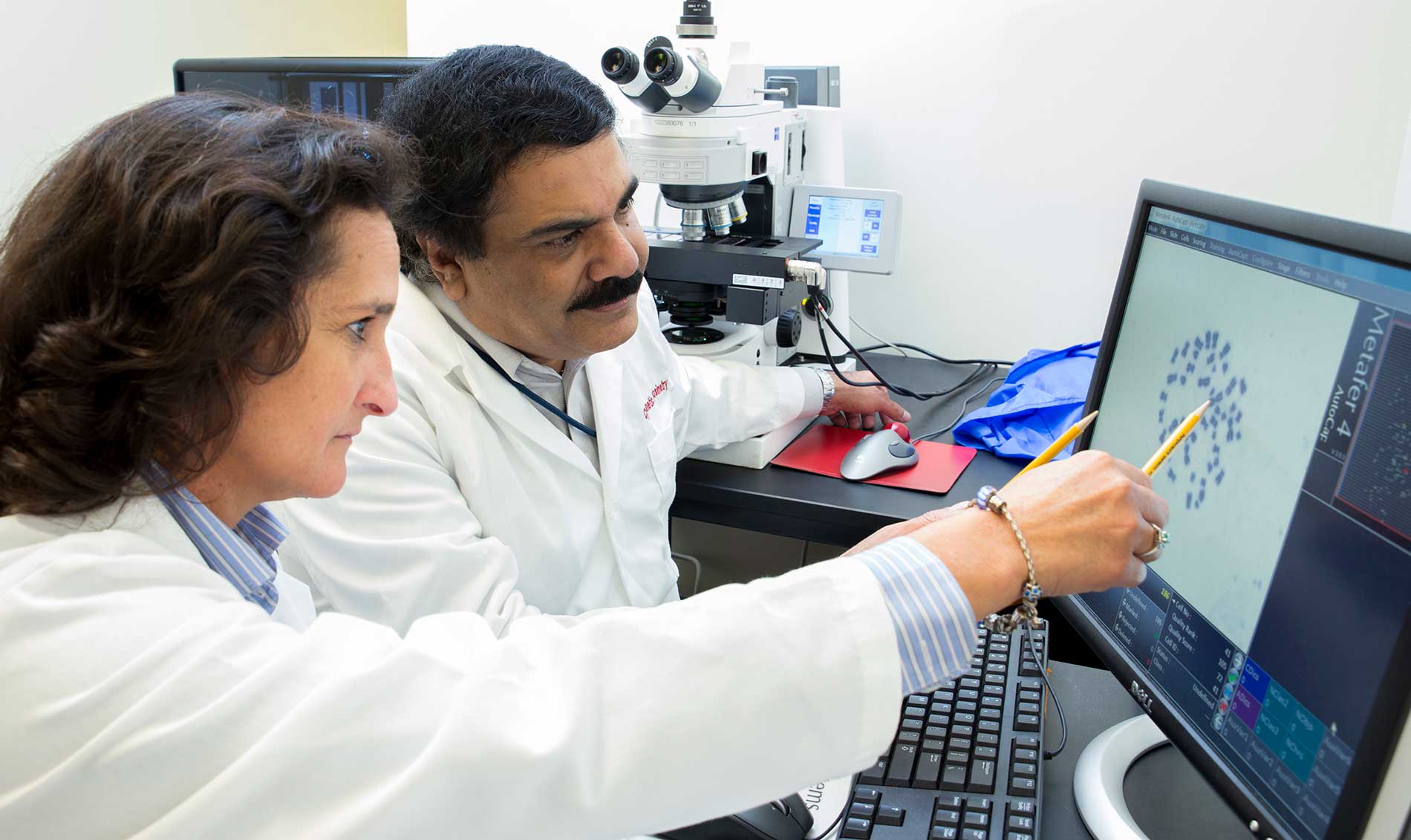 باحثان يدققان في صورة كمبيوترية للكروموسومات 