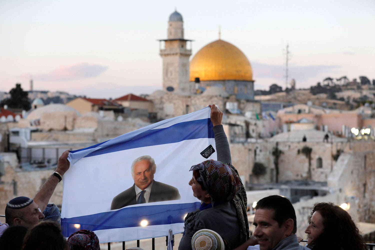 إسرائيليون يلوحون بصورة نتانياهو على علم إسرائيلي في المدينة القديمة