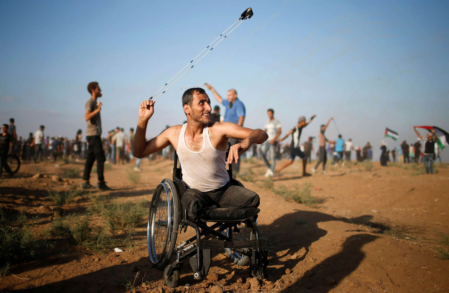 معوق فلسطيني يلقي بالحجارة على جنود إسرائيليين على حدود غزة