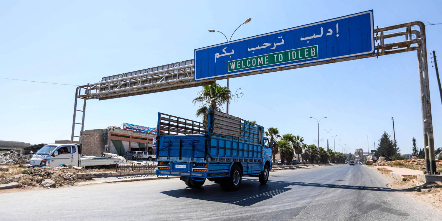 شاحنة تمر تحت إشارة مرورية في الطريق المؤدي إلى إدلب