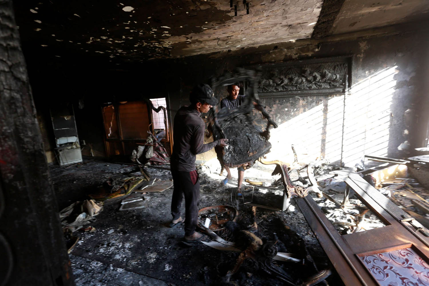 عراقي يرفع الانقاض بعد حريق في مسكن مسؤول عراقي