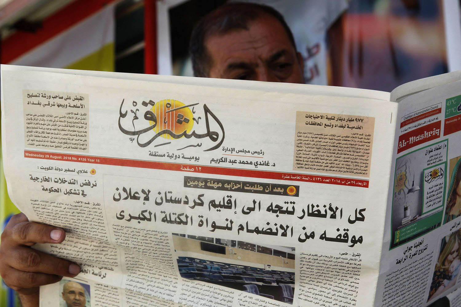 عراقي يتصفح صحيفة محلية