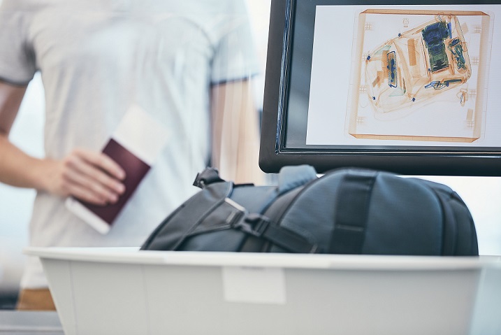 مسافر يمر على جهاز تفتيش حقائب بالاشعة في مطار