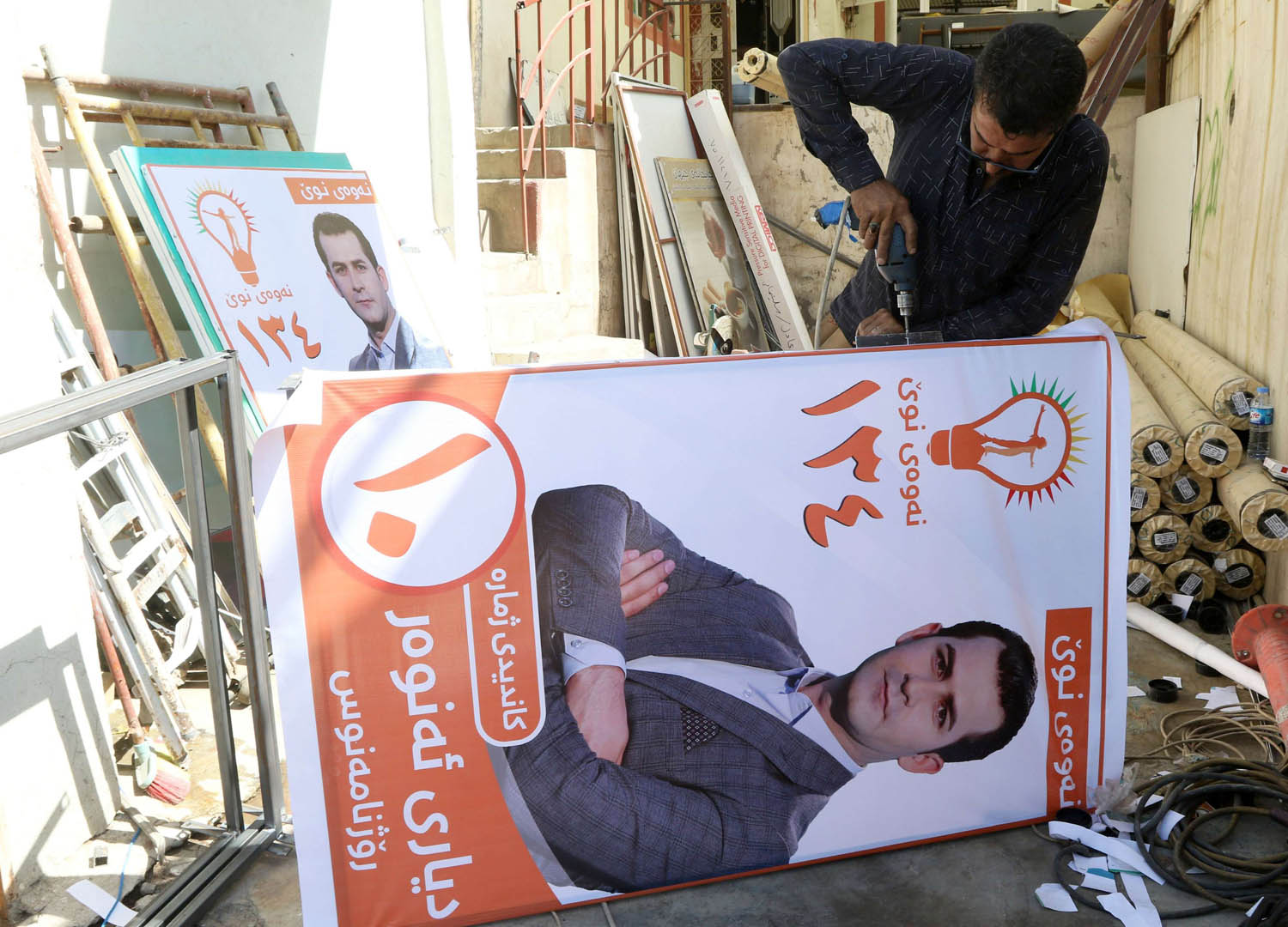 كردي عراقي يثبت ملصقا في السليمانية للانتخابات الكردية المقبلة