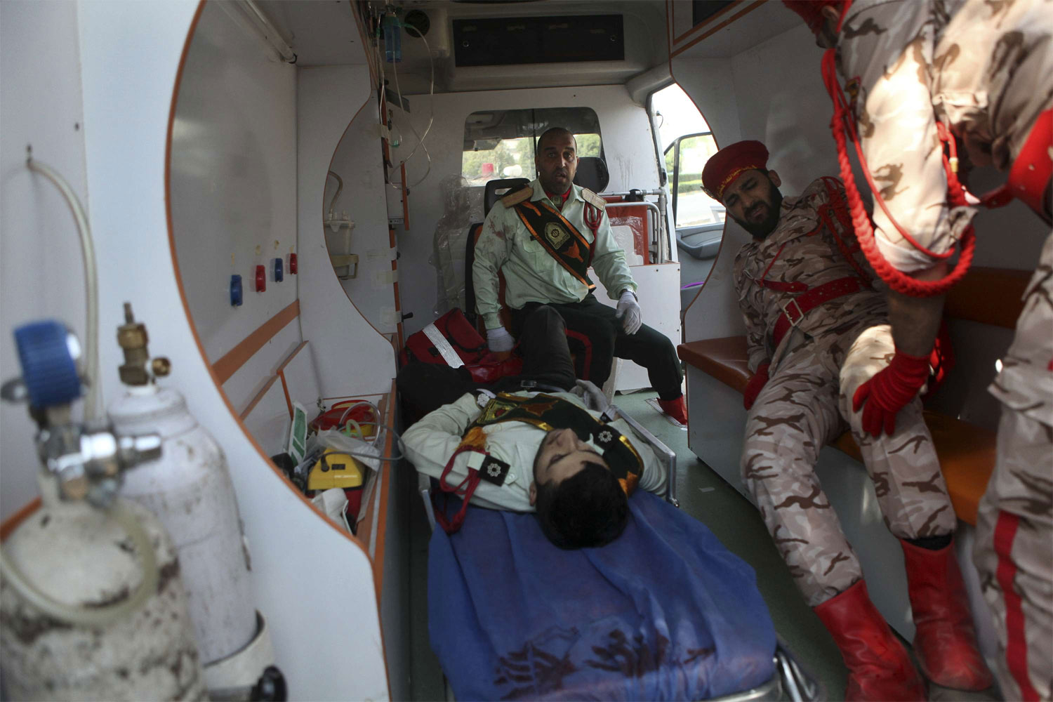 Wounded military personnel are carried into an ambulance after the shooting