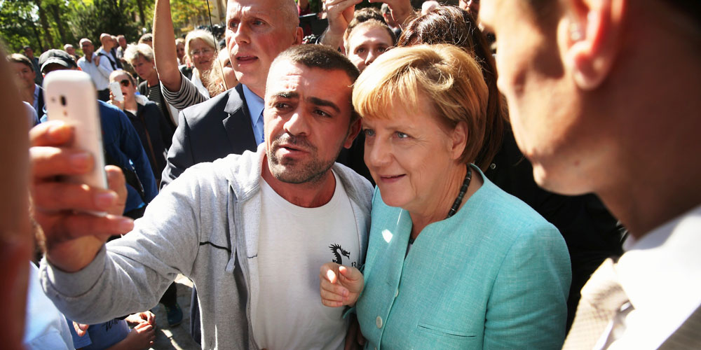 المستشارة الألمانية انجيلا ميركل في سلفي مع أحد اللاجئين السوريين