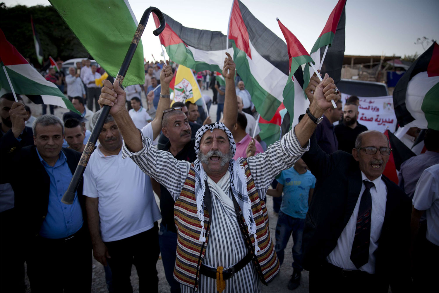 Palestinians protesters fly national flags and chant anti Israel slogans in the West Bank hamlet of Khan al-Ahmar 