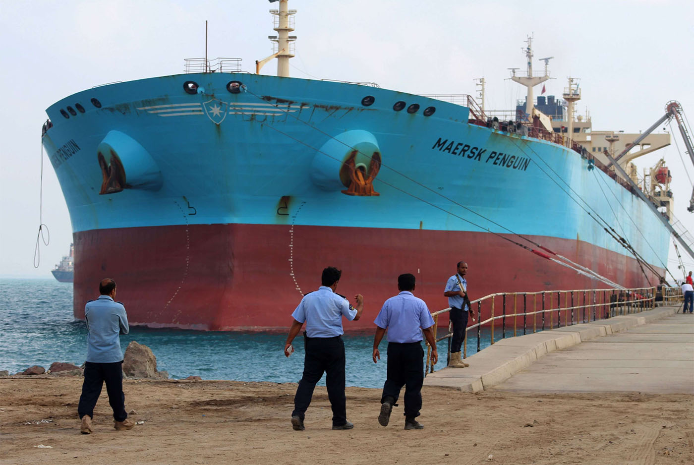 Security guards stand by a ship docked in the southern Yemeni port of Aden