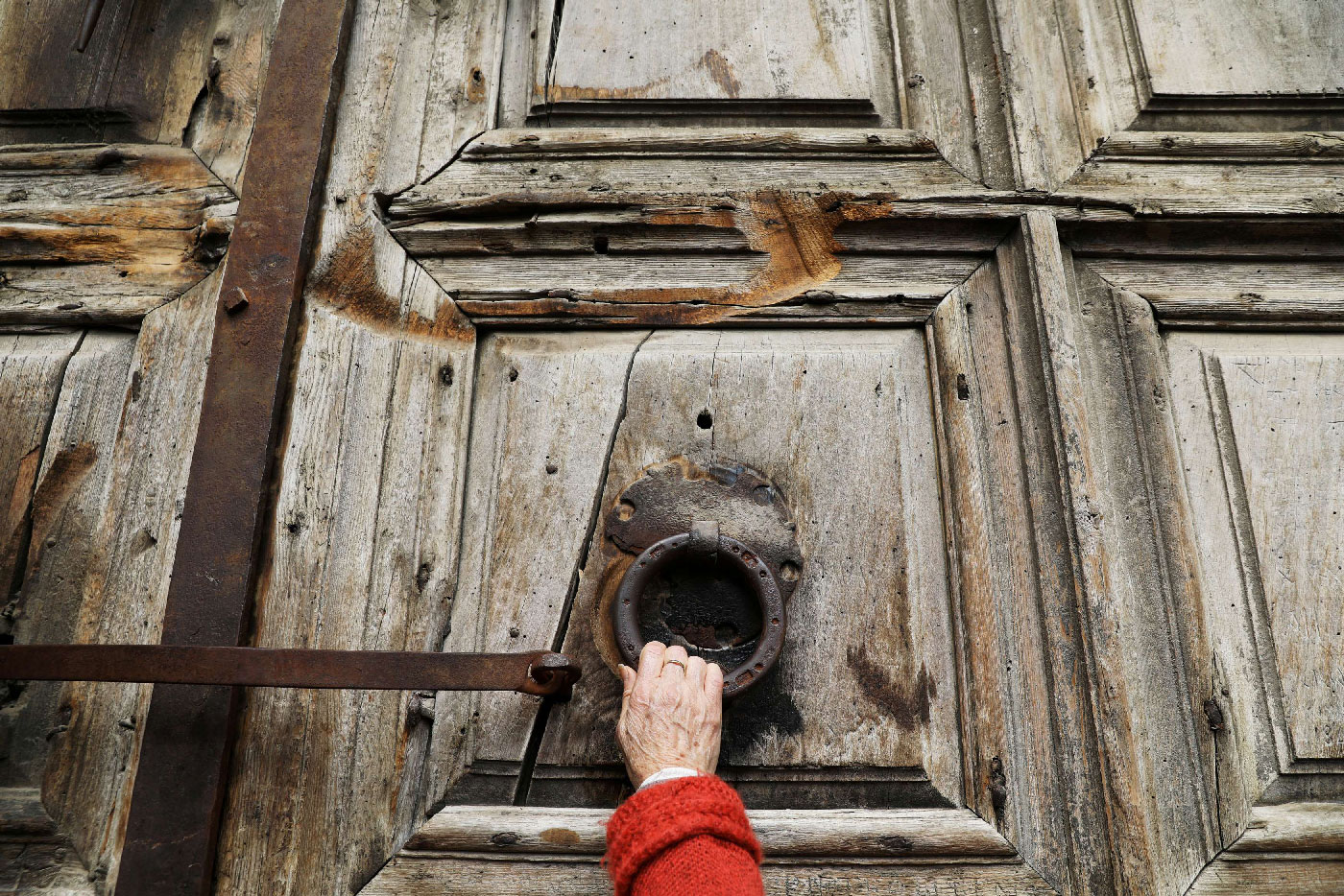 A worshipper touches the closed doors of the Church of the Holy Sepulchre.