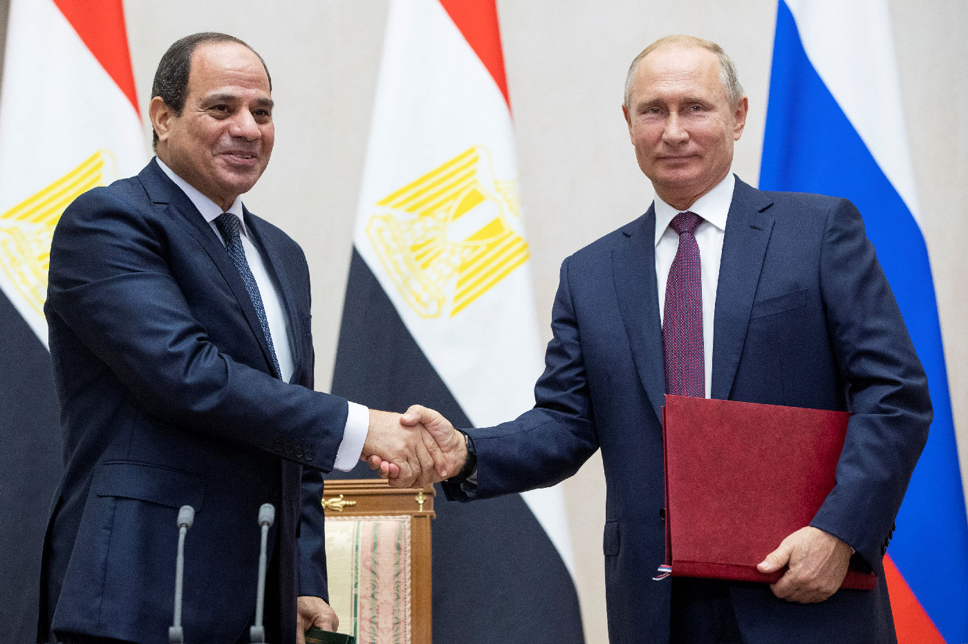 Russian President Vladimir Putin and Egyptian President Abdel Fattah al-Sisi shake hands.