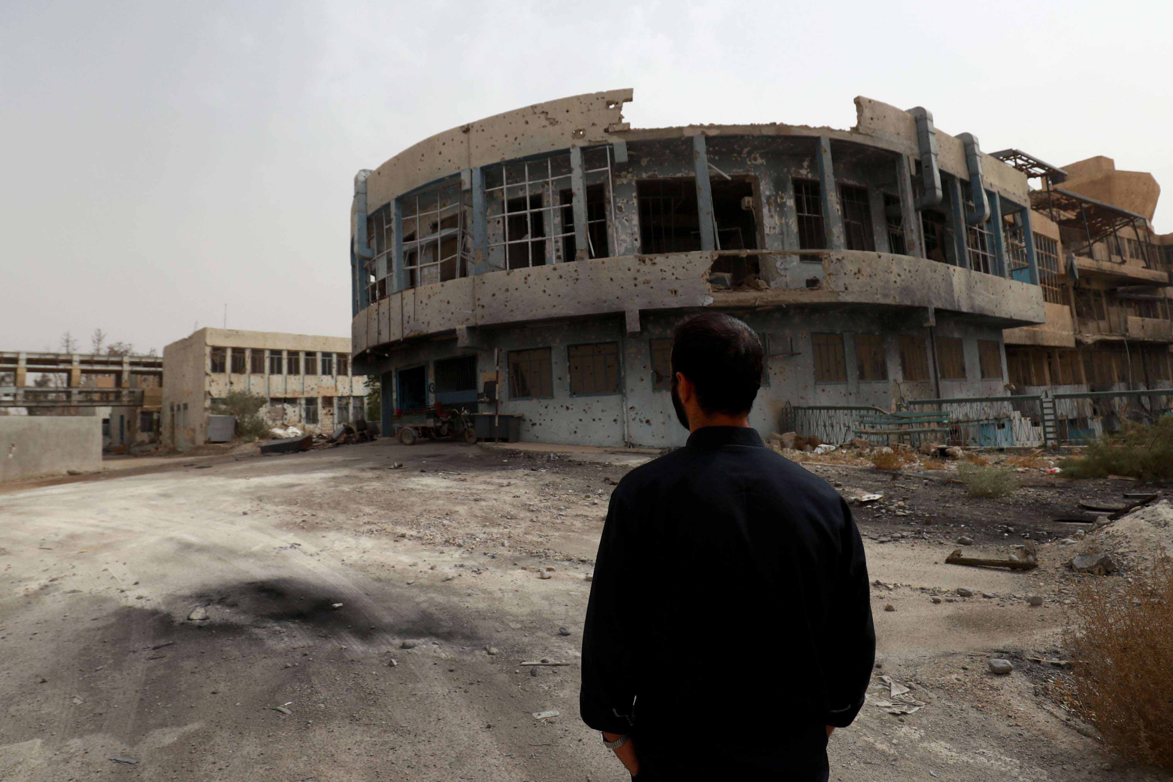 A member of the first response team tours the courtyard of the National Hospital building in the northern Syria city of Raqa