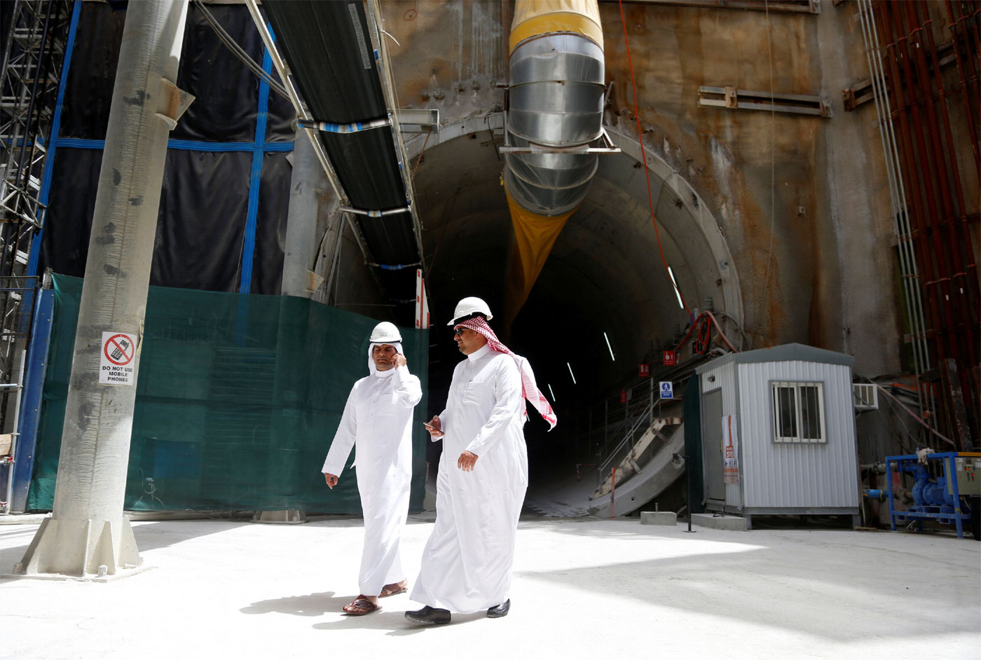 Men walk at the construction site of Riyadh Metro