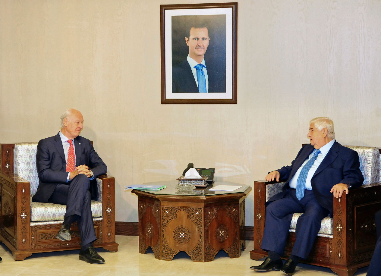 Syria's Foreign Minister Walid al-Muallem, right, meets with UN Special Envoy for Syria Staffan de Mistura.