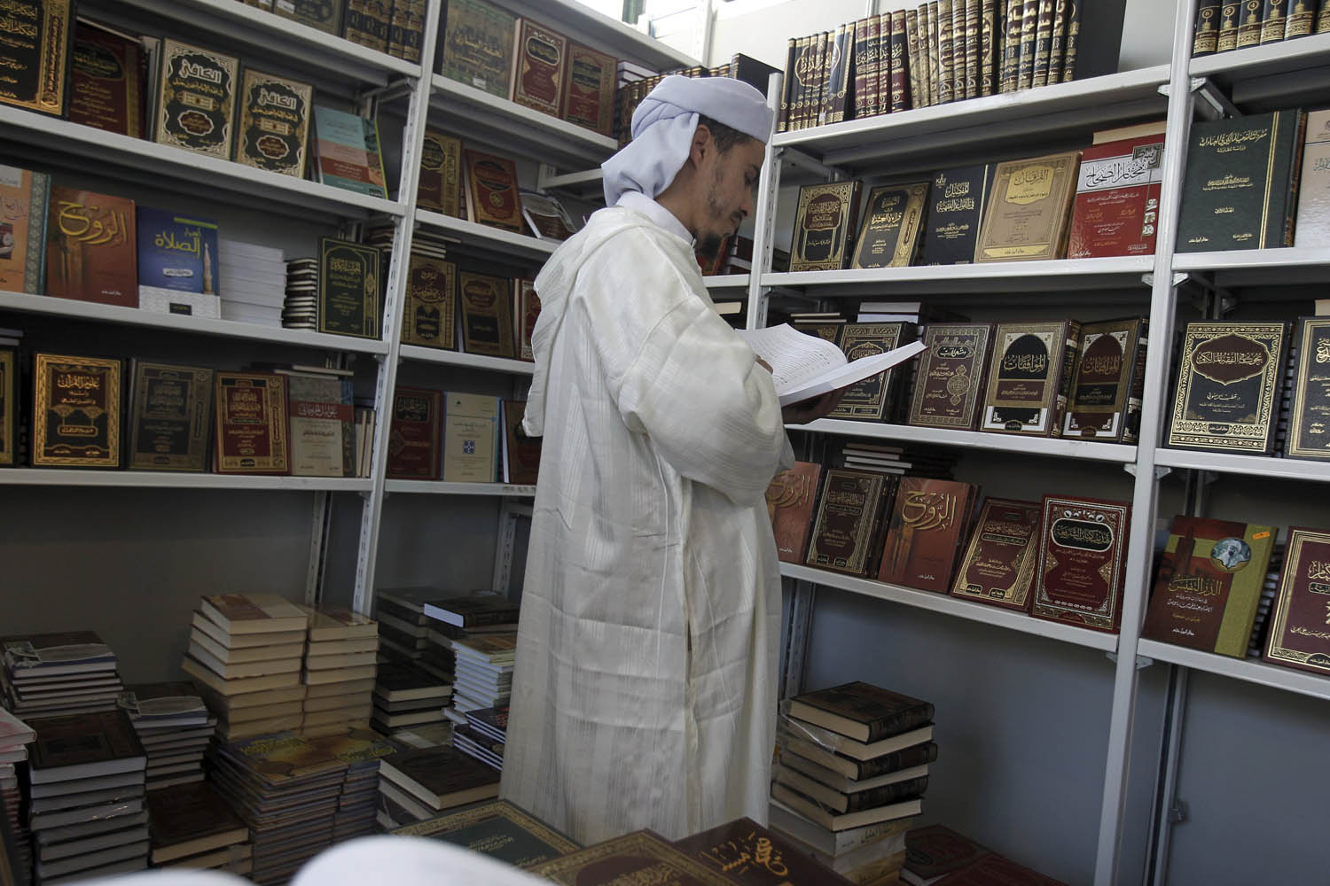 جزائري يتصفح كتبا دينية في معرض الجزائر للكتاب