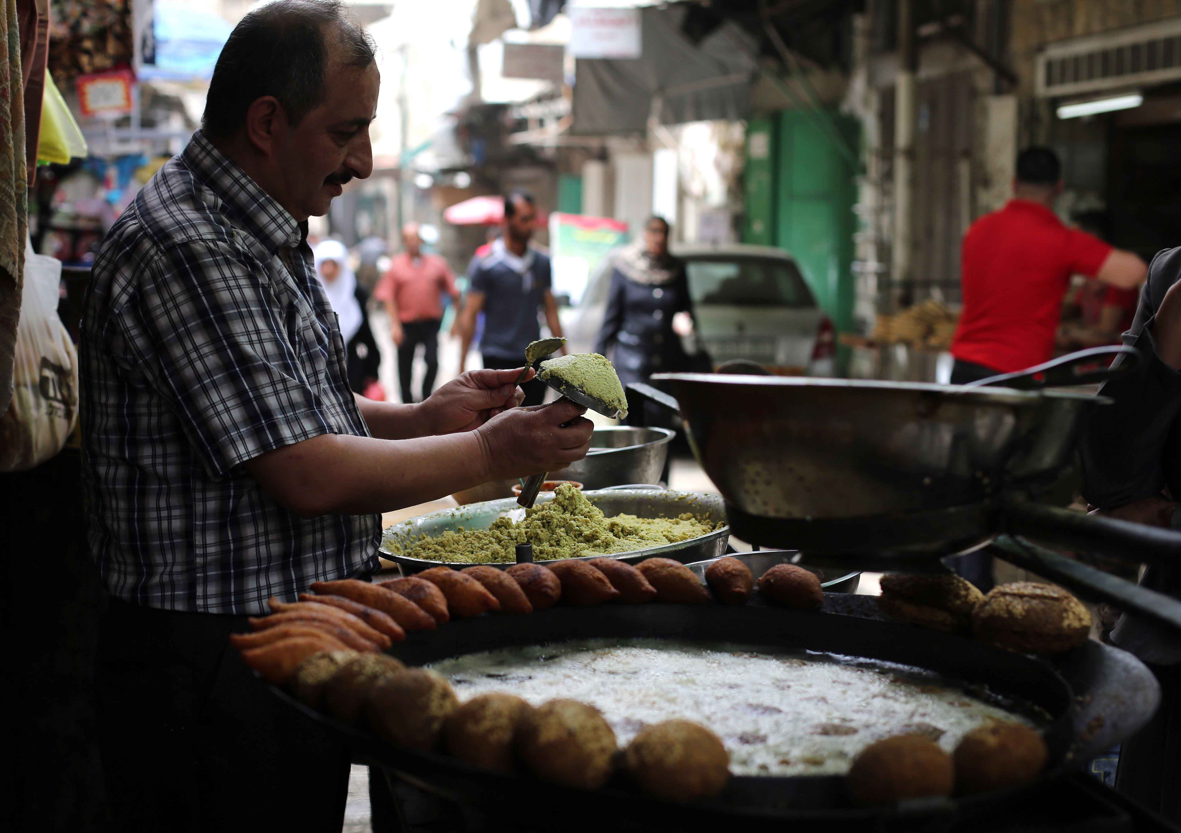 More than what’s on a plate. A Palestinian man makes falafel, a traditional dish consisting of fried chickpeas, on a street in Nablus