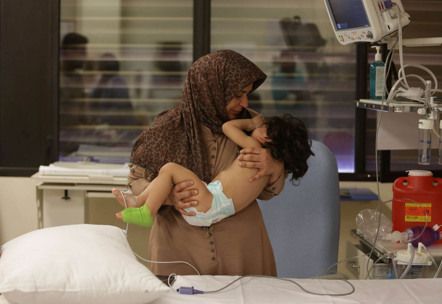 ليبية تحتضن ابنتها بعد اجراء فريق طبي أميركي عملية لها في مستشفى ببنغازي