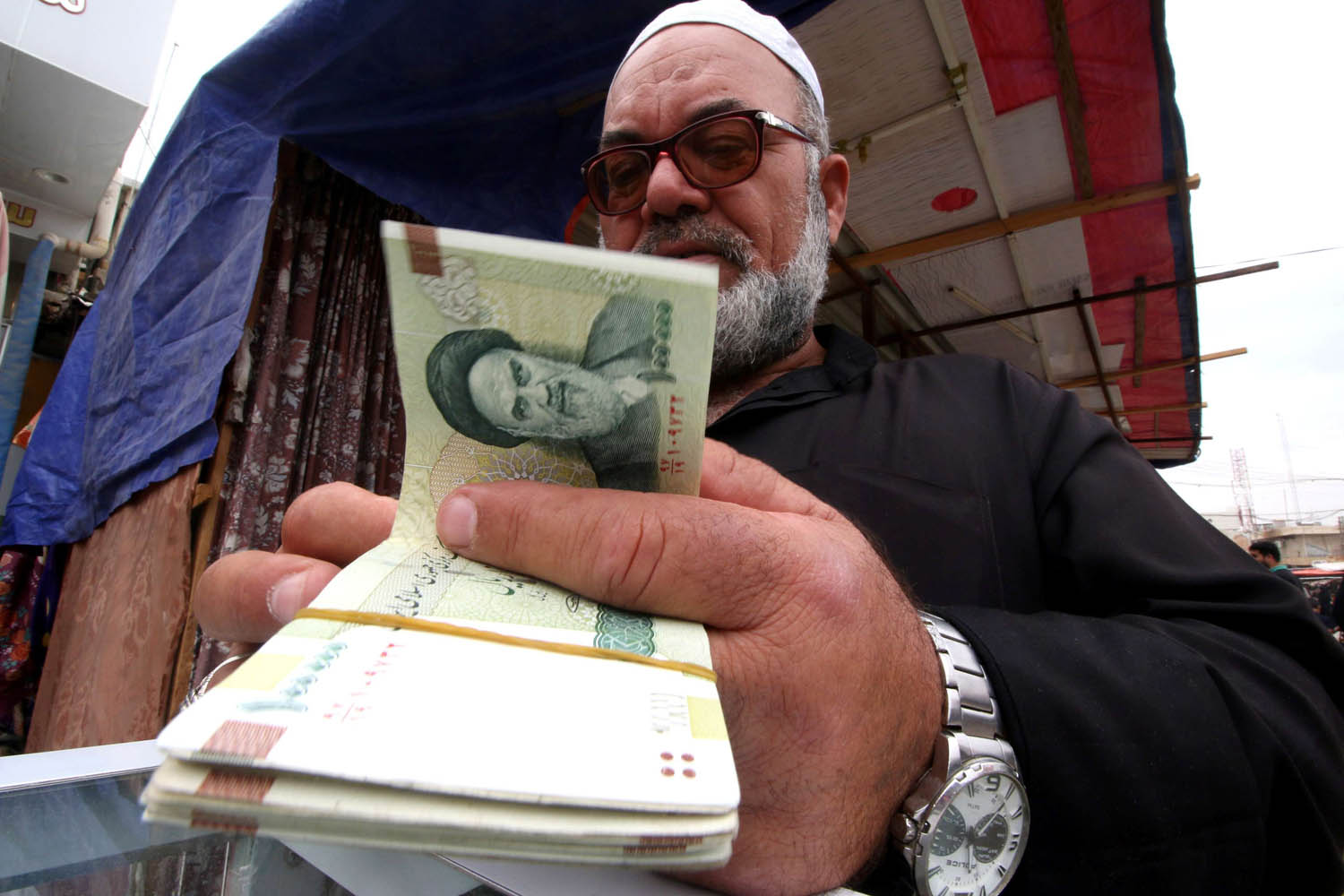 صراف عراقي يعد العملة الإيرانية في البصرة