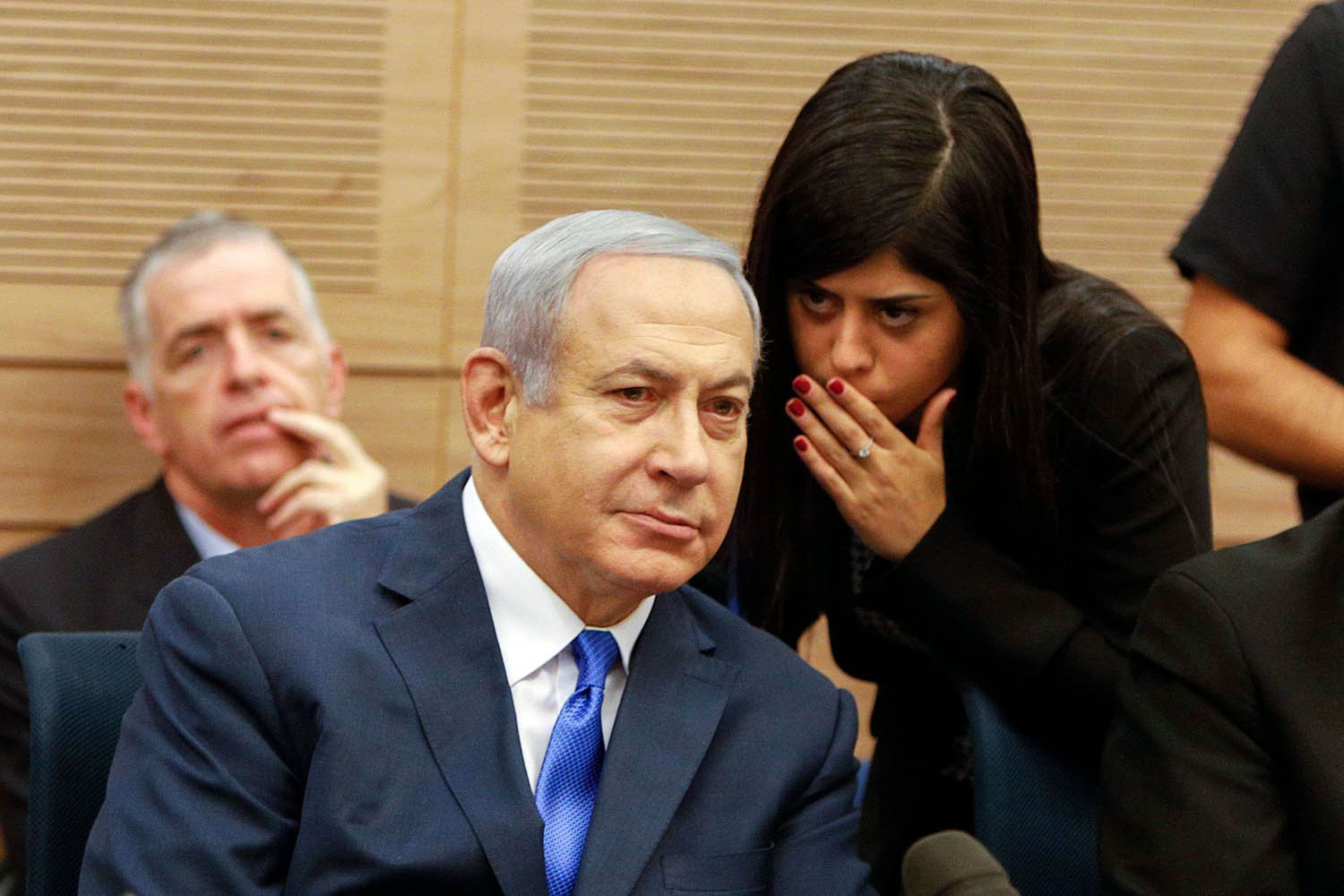 رئيس الوزراء الاسرائيلي بنيامين نتانياهو يستمع إلى همس مستشارة له