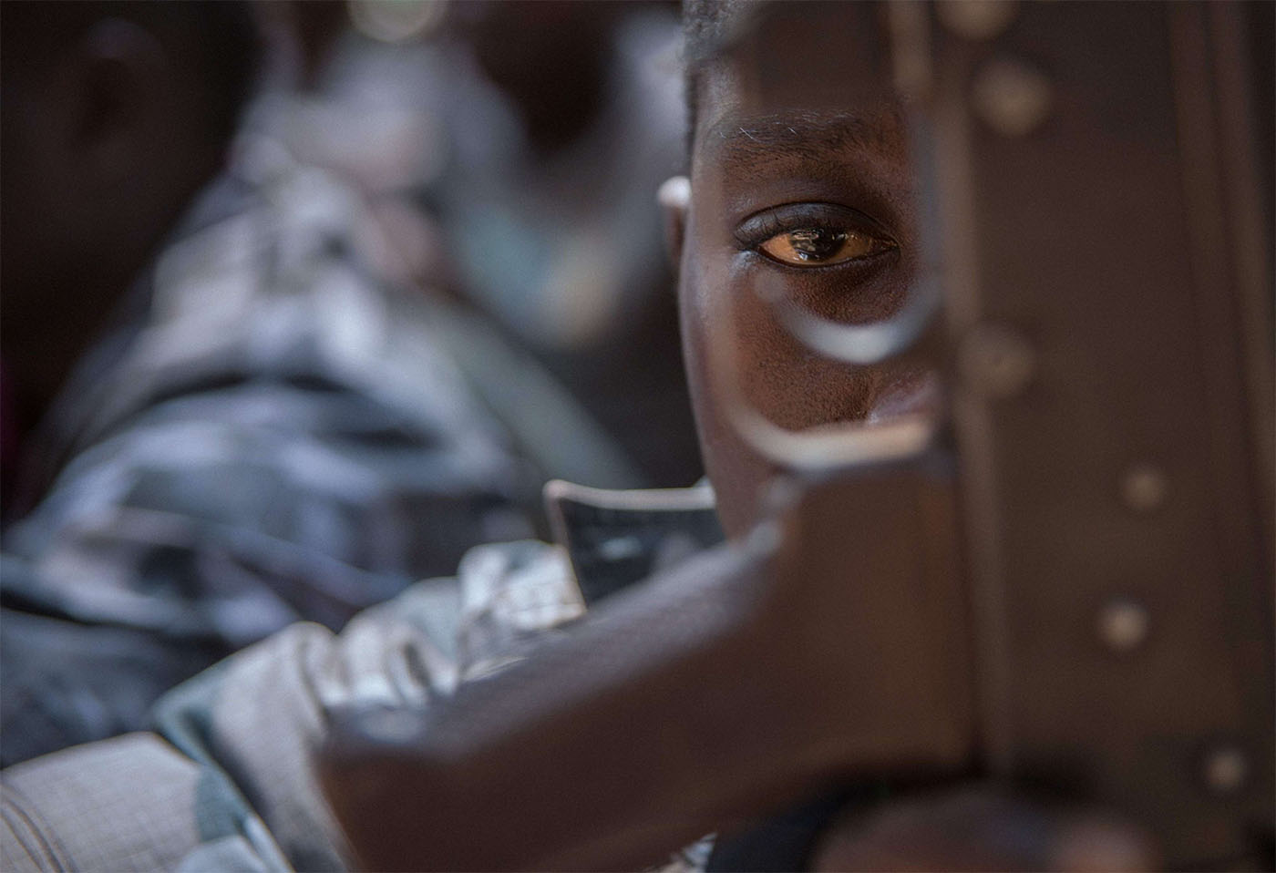 A released child soldier last February looks through a rifle trigger guard during a release ceremony for child soldiers in Yambio, South Sudan