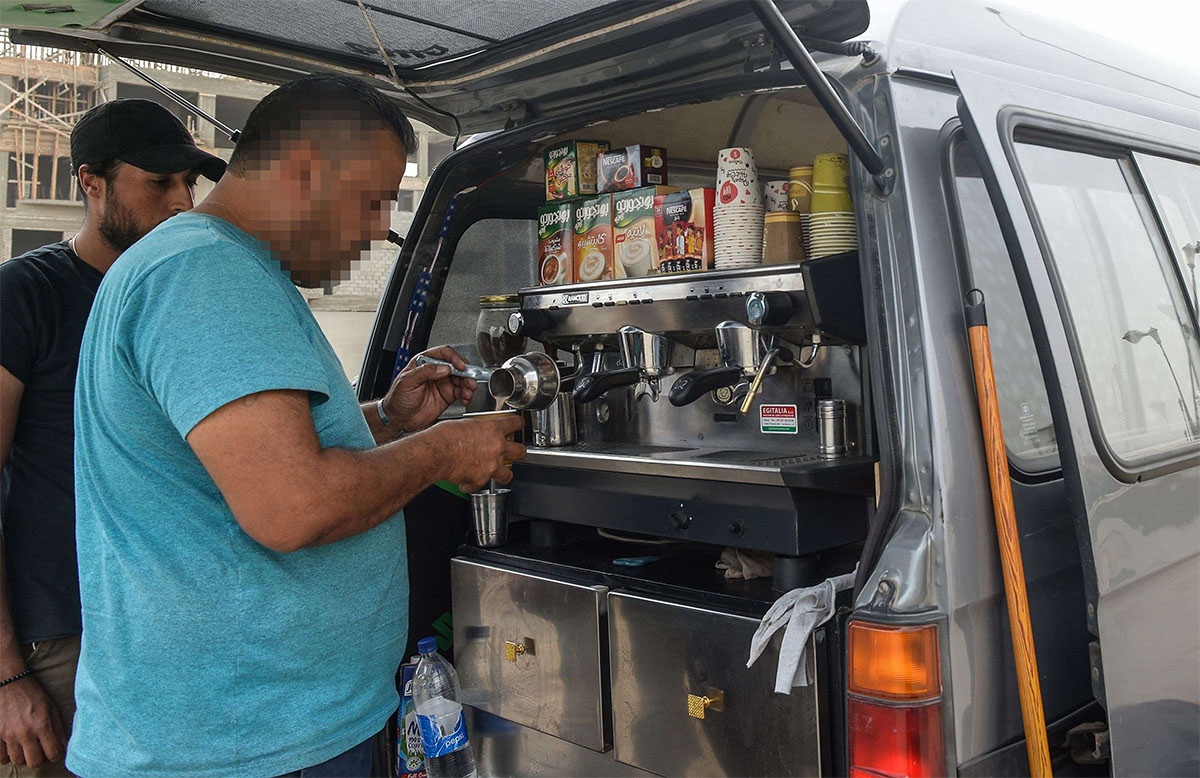 A Syrian refugee prepares coffee at the back of an improvised food truck in the Egyptian capital Cairo 