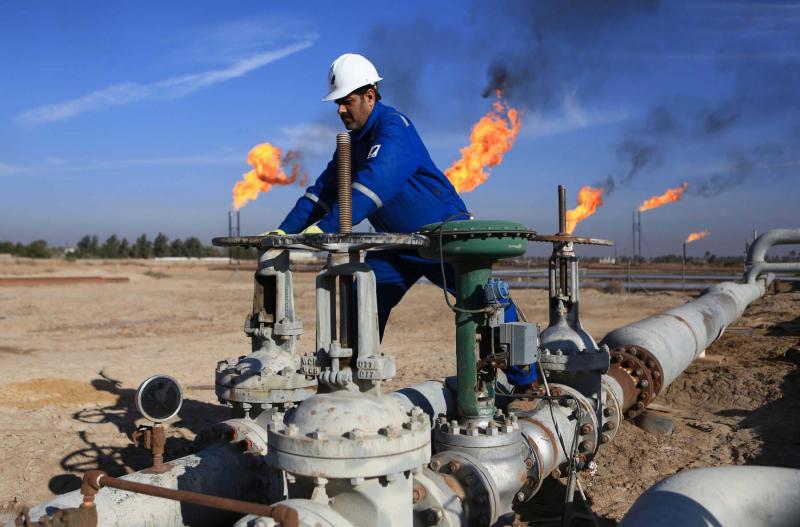An Iraqi worker operates valves in Nihran Bin Omar oilfield, north of Basra