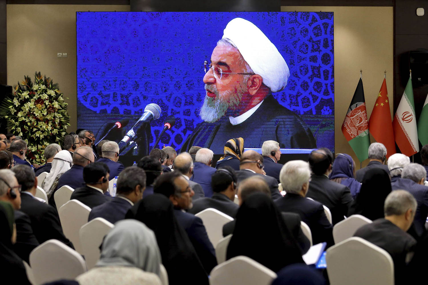 مشاركون في مؤتمر في طهران يستمعون إلى كلمة الرئيس الإيراني حسن روحاني