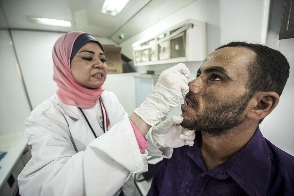 ممرضة تفحص مواطنا مصريا ضمن الحملة على فيروس سي