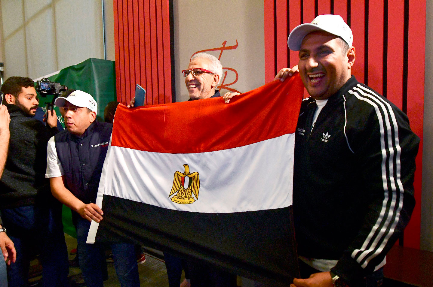 Egyptian representatives pose with their national flag as they celebrate the Confederation of African Football (CAF) executive committee's decision to choose Egypt to host the 2019 Africa Cup of Nations between June 15 and July 13, in an Hotel in Dakar on January 8, 2019.