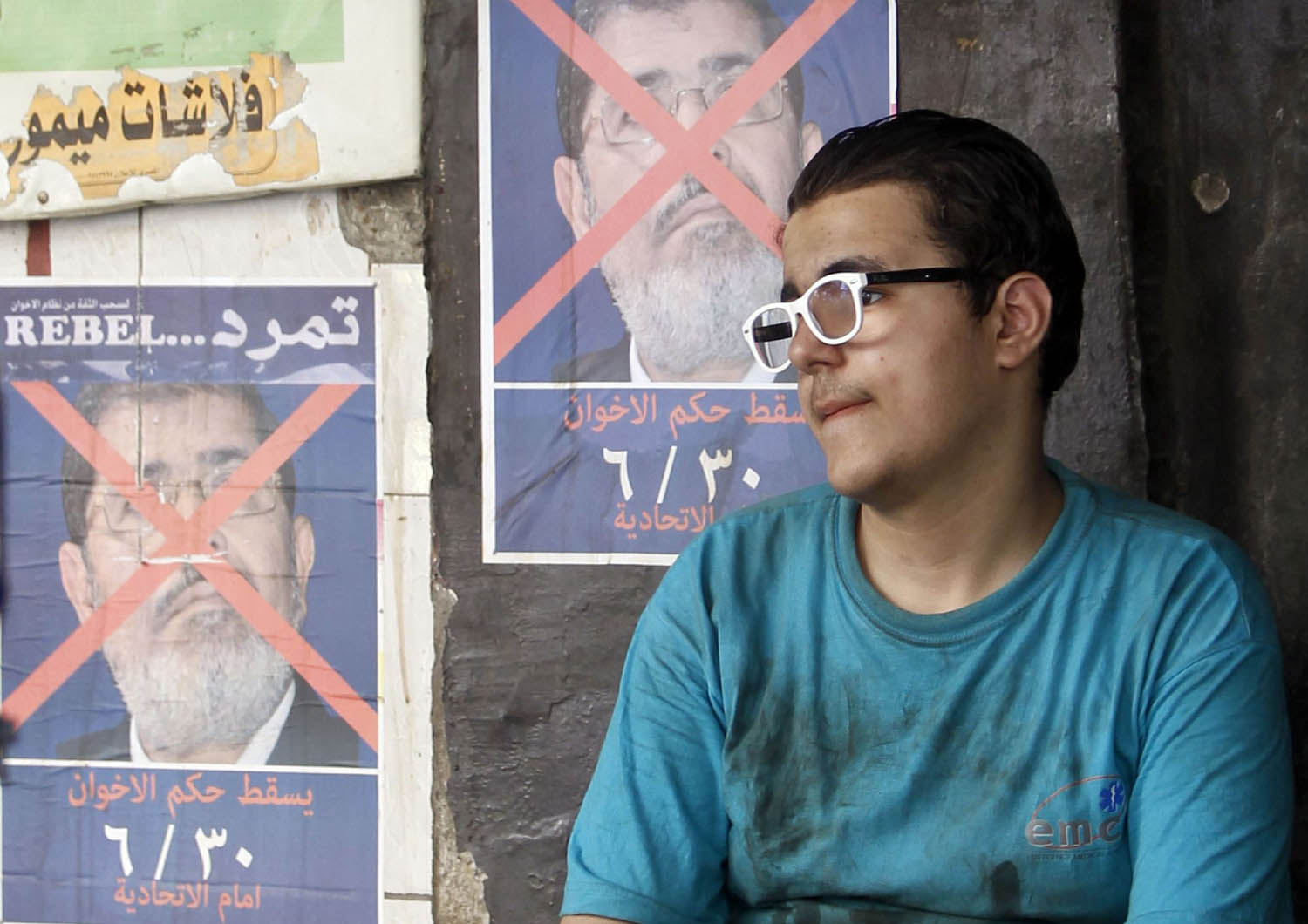 ناشط مصري بجانب صورة للرئيس السابق محمد مرسي خلال تظاهرات 2013