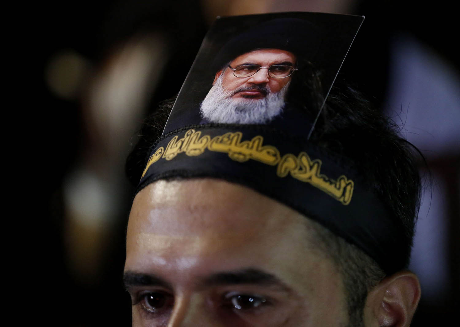 ناشط من حزب الله يرفع صورة لحسن نصرالله على رأسه